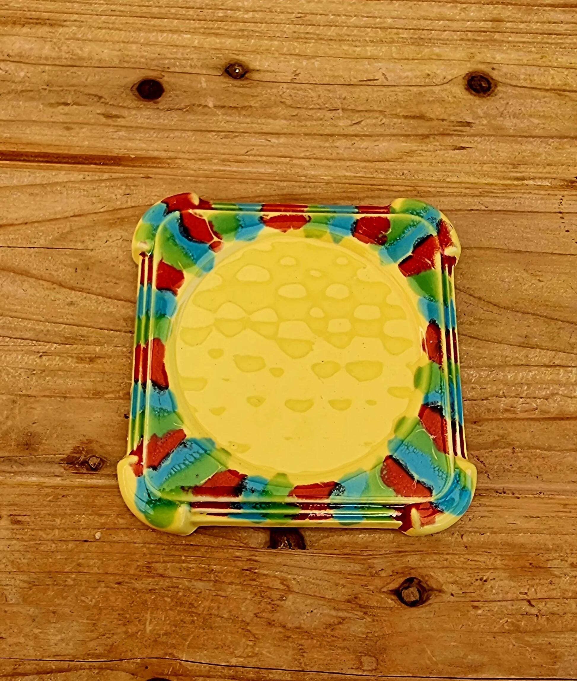 Yellow ceramic trivet and bottle coaster with vintage painted decoration.