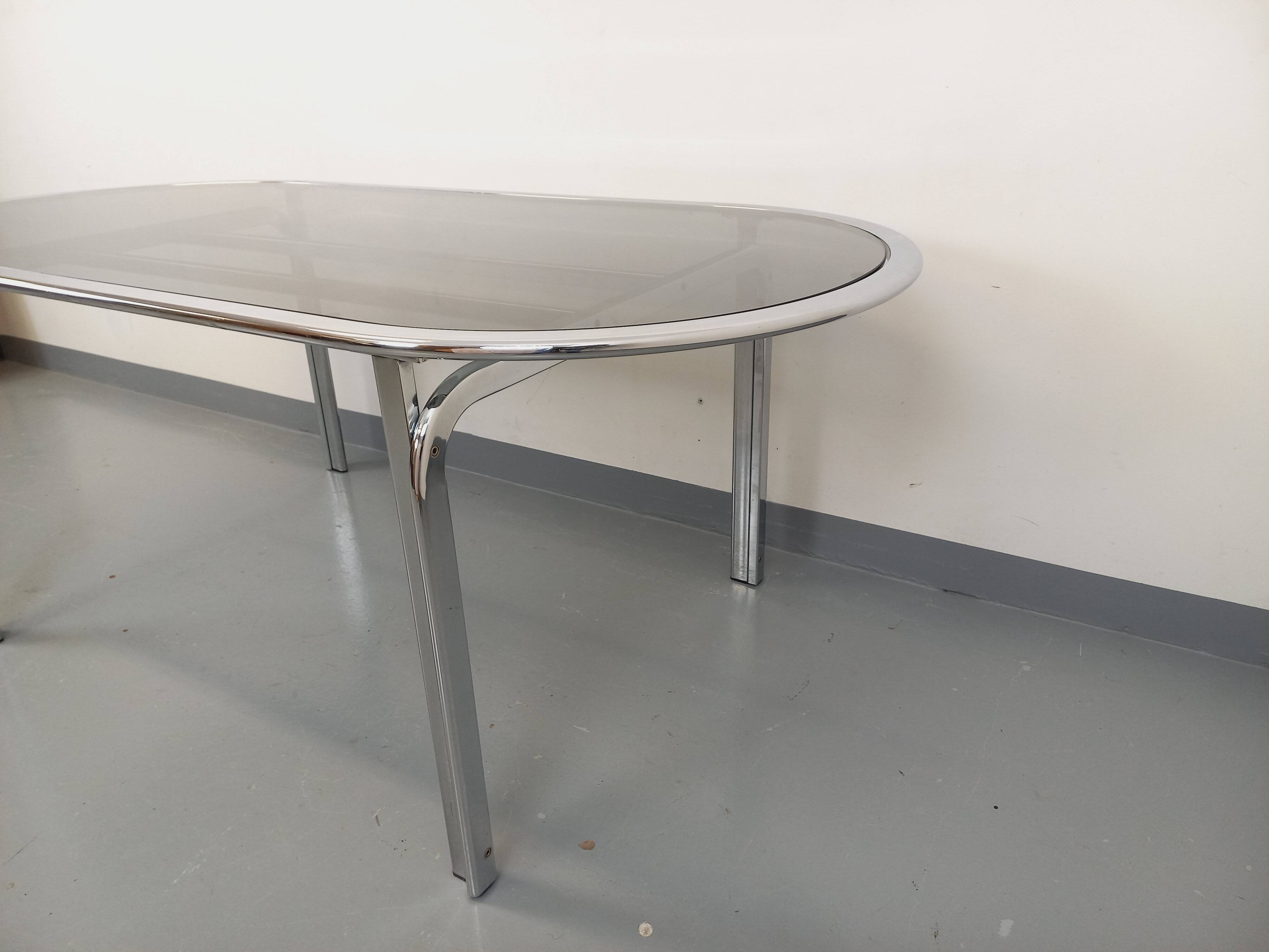 Vintage oval dining table in smoked glass and chrome metal, Space Age style.