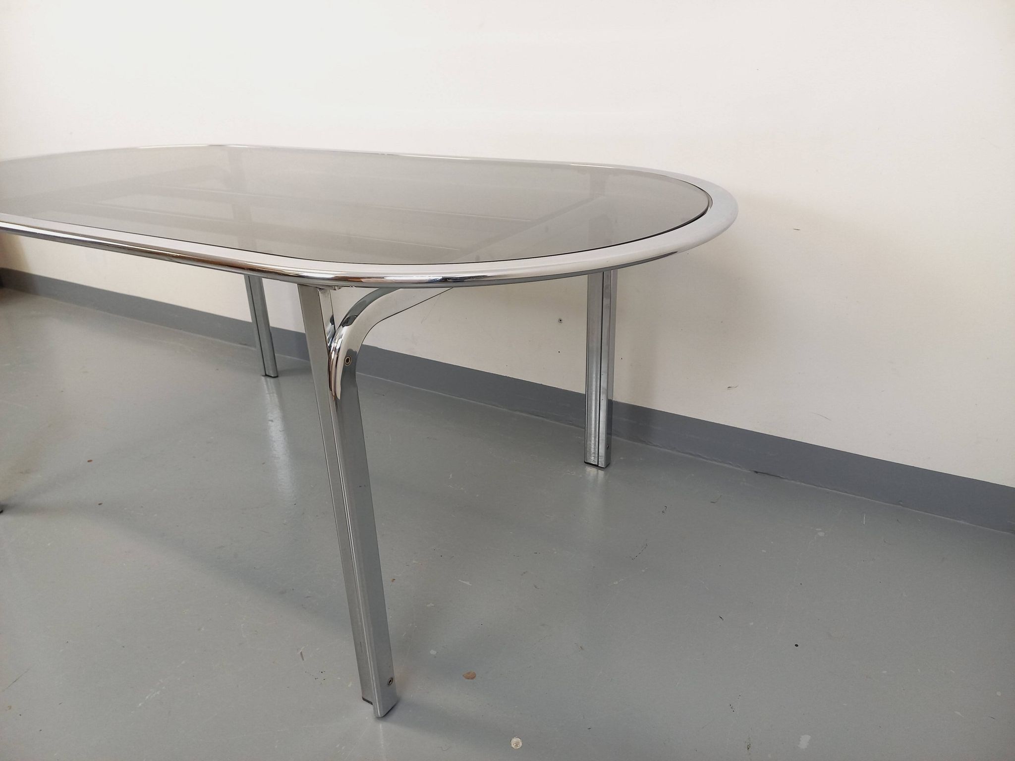 Vintage oval dining table in smoked glass and chrome metal, Space Age style.