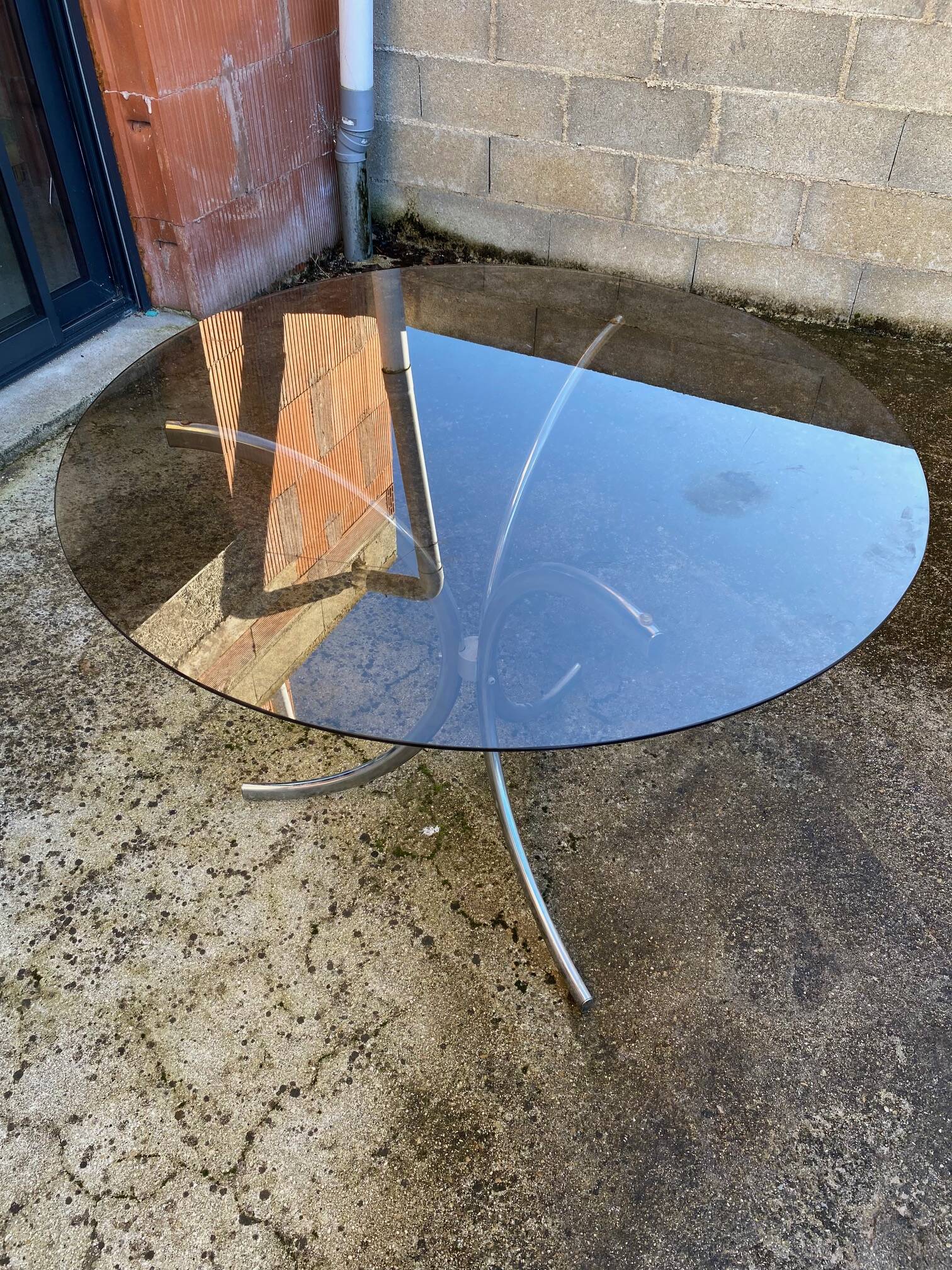 Table with chrome metal legs and smoked glass top.