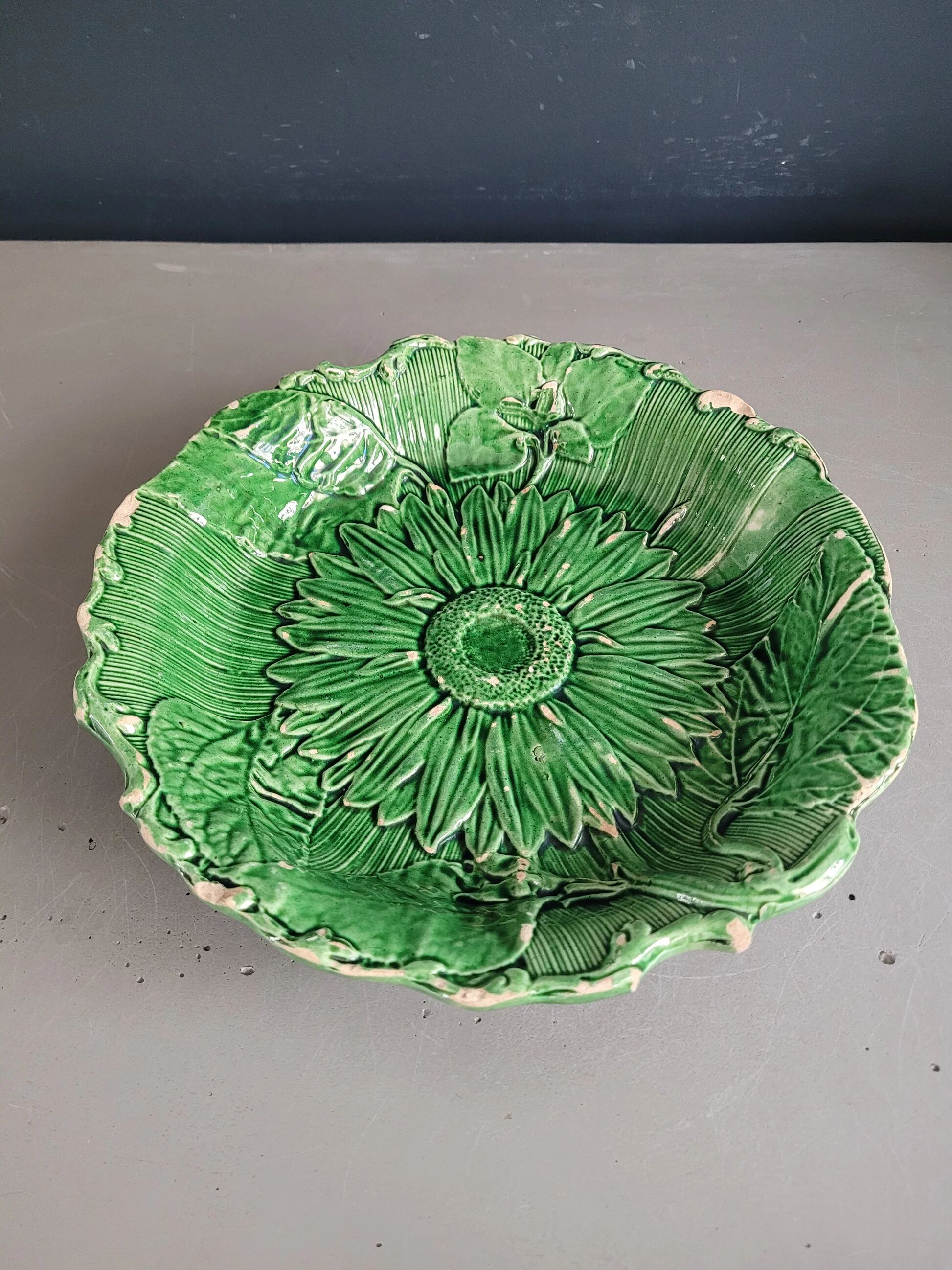 Plate decorated with a sunflower motif in slipware.