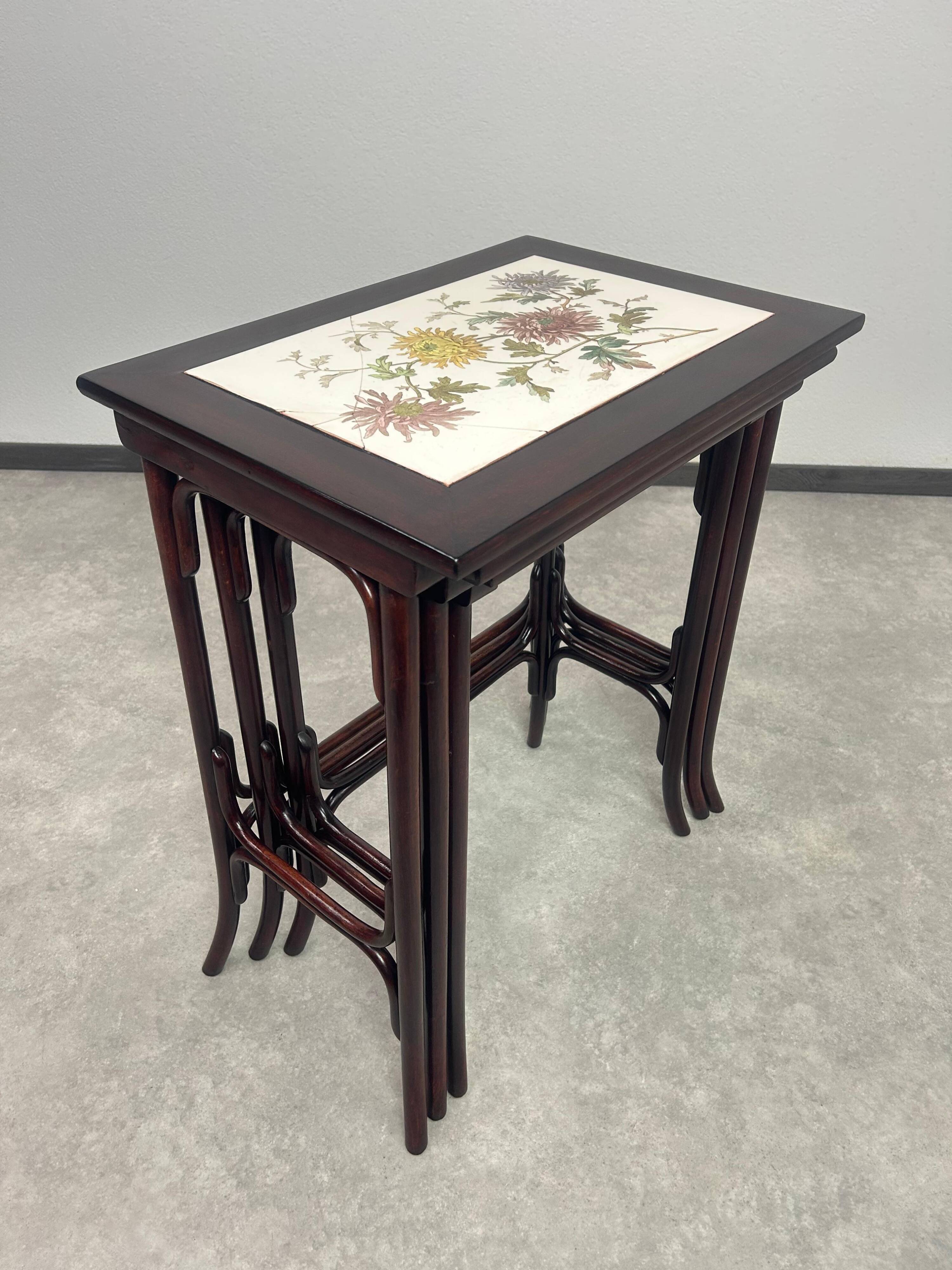 Nested tables in curved wood with ceramic top by Thonet.