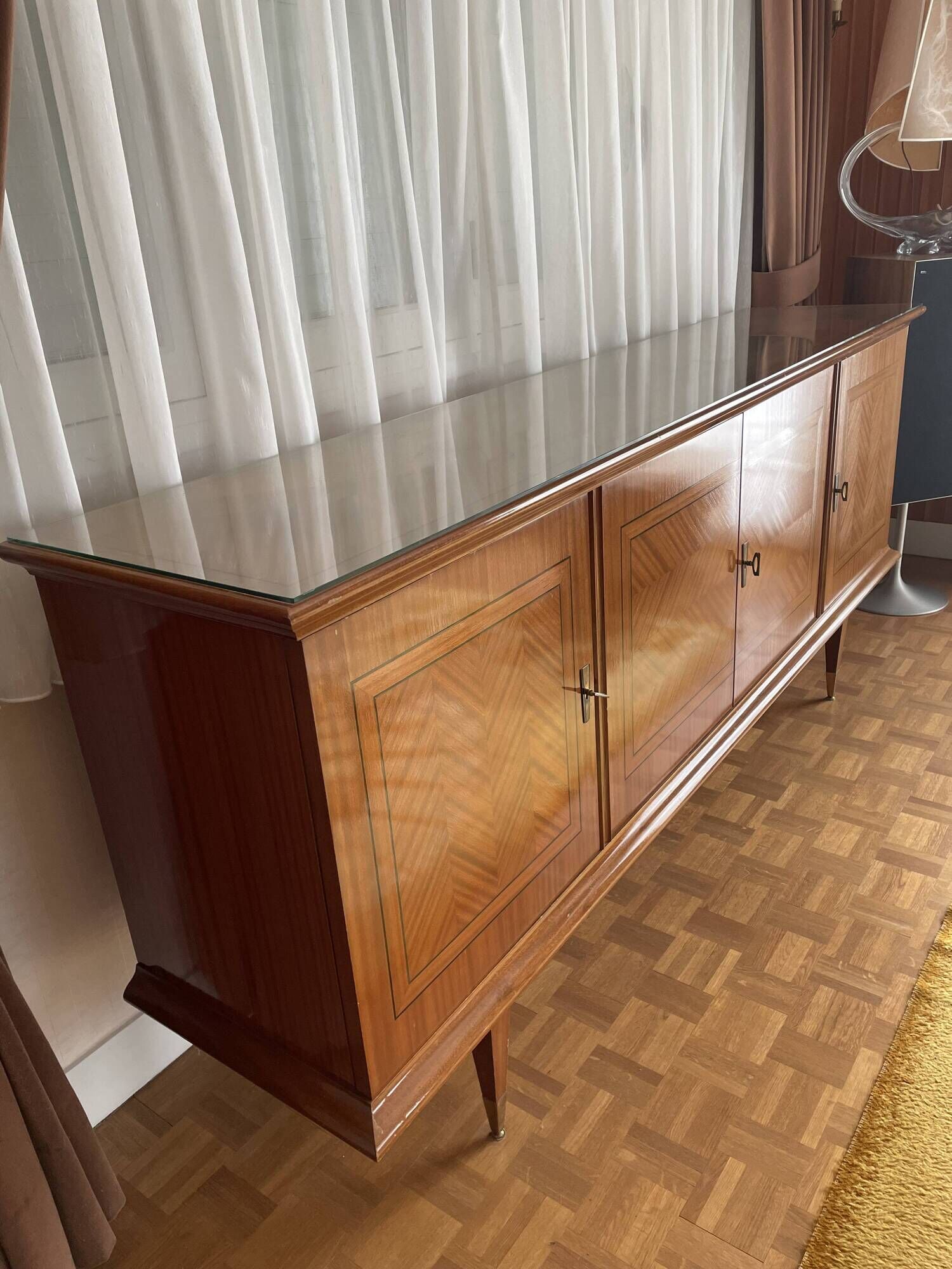 Vintage 4-door buffet with wood veneer and glass top.