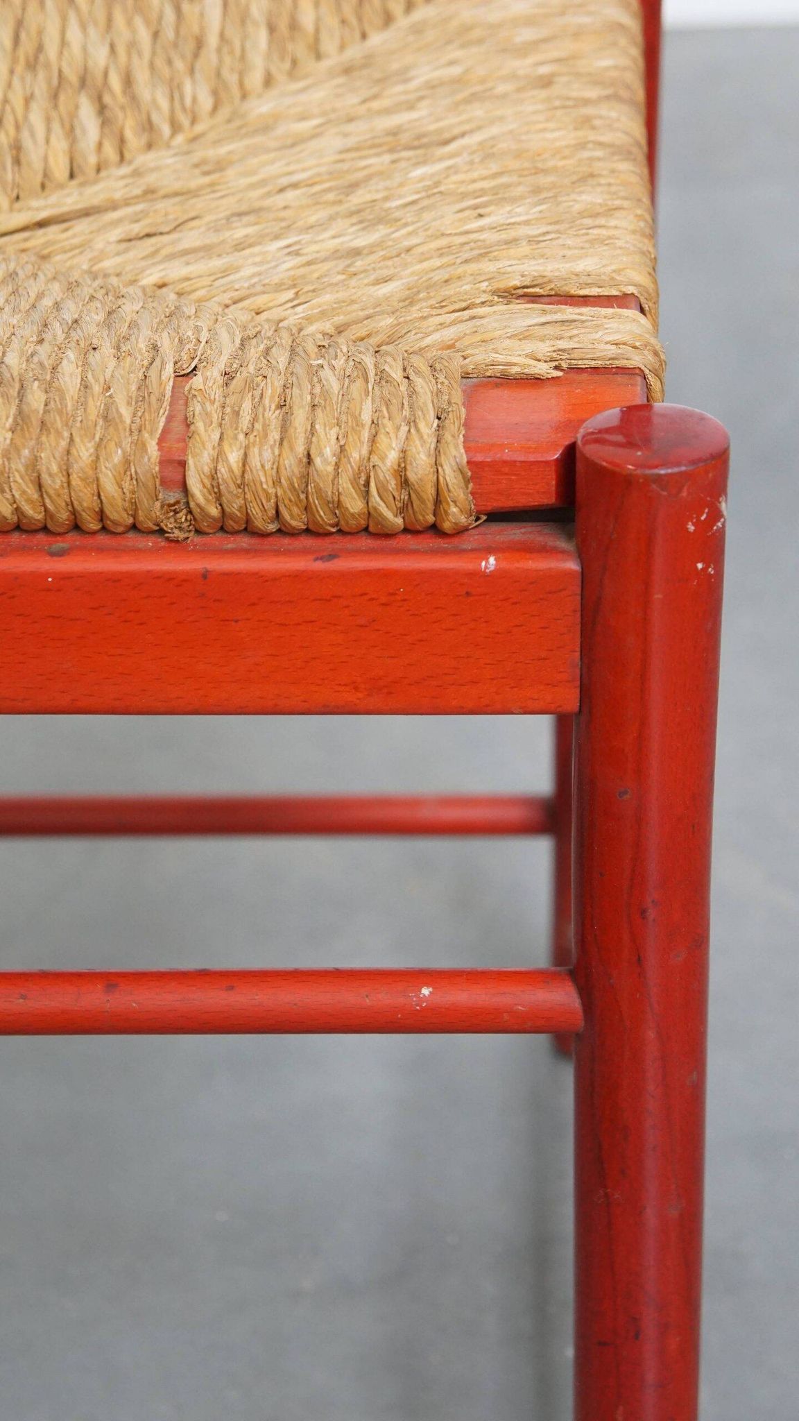 Vintage 1970s red wooden chair with a woven wicker seat