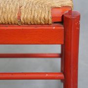 Vintage 1970s red wooden chair with a woven wicker seat