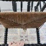 Antique black turned wood corner chair with a straw seat.