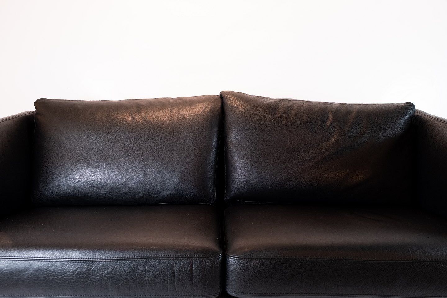 Two seater sofa upholstered with black leather and of danish design