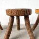 Set of three rustic solid wood tripod stools.