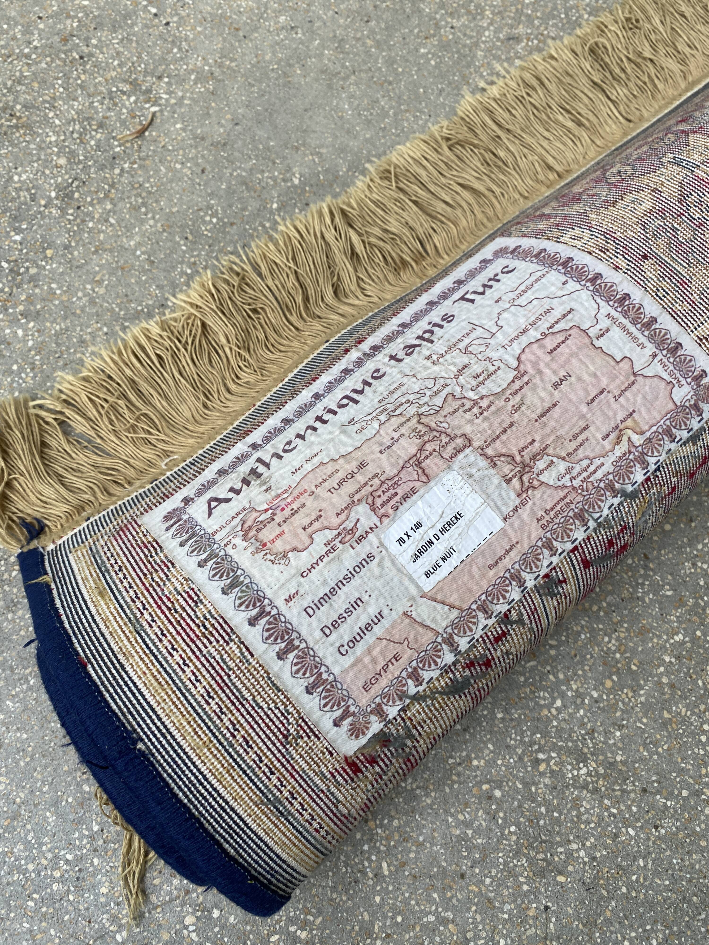 Vintage mechanical Turkish rug with box decoration on a red and navy blue background 139 x 68 cm