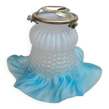 An antique lampshade in frosted glass with delicate blue edges.