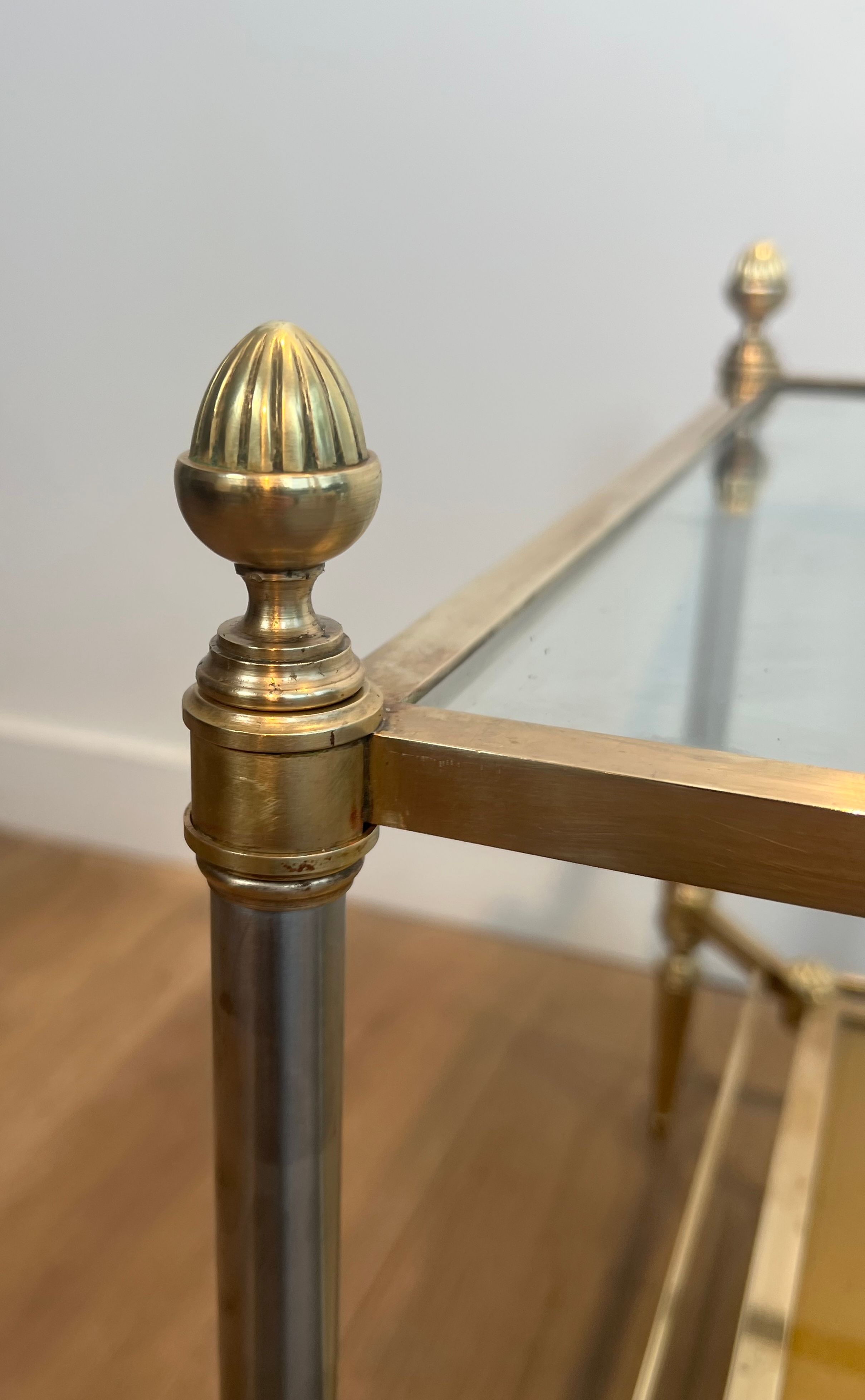 Coffee table in brass, brushed steel, glass, and gilded eglomisé mirror from Maison Jansen.