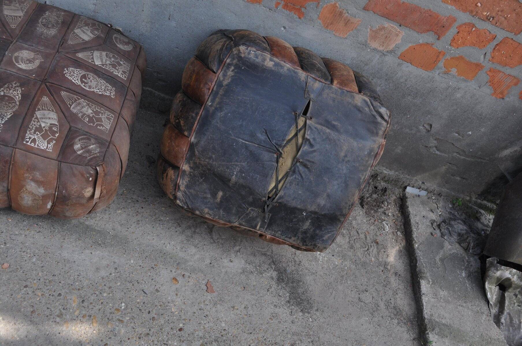 Set of 2 vintage ottomans in brown and black leather with Egyptian patterns from the 1970s.