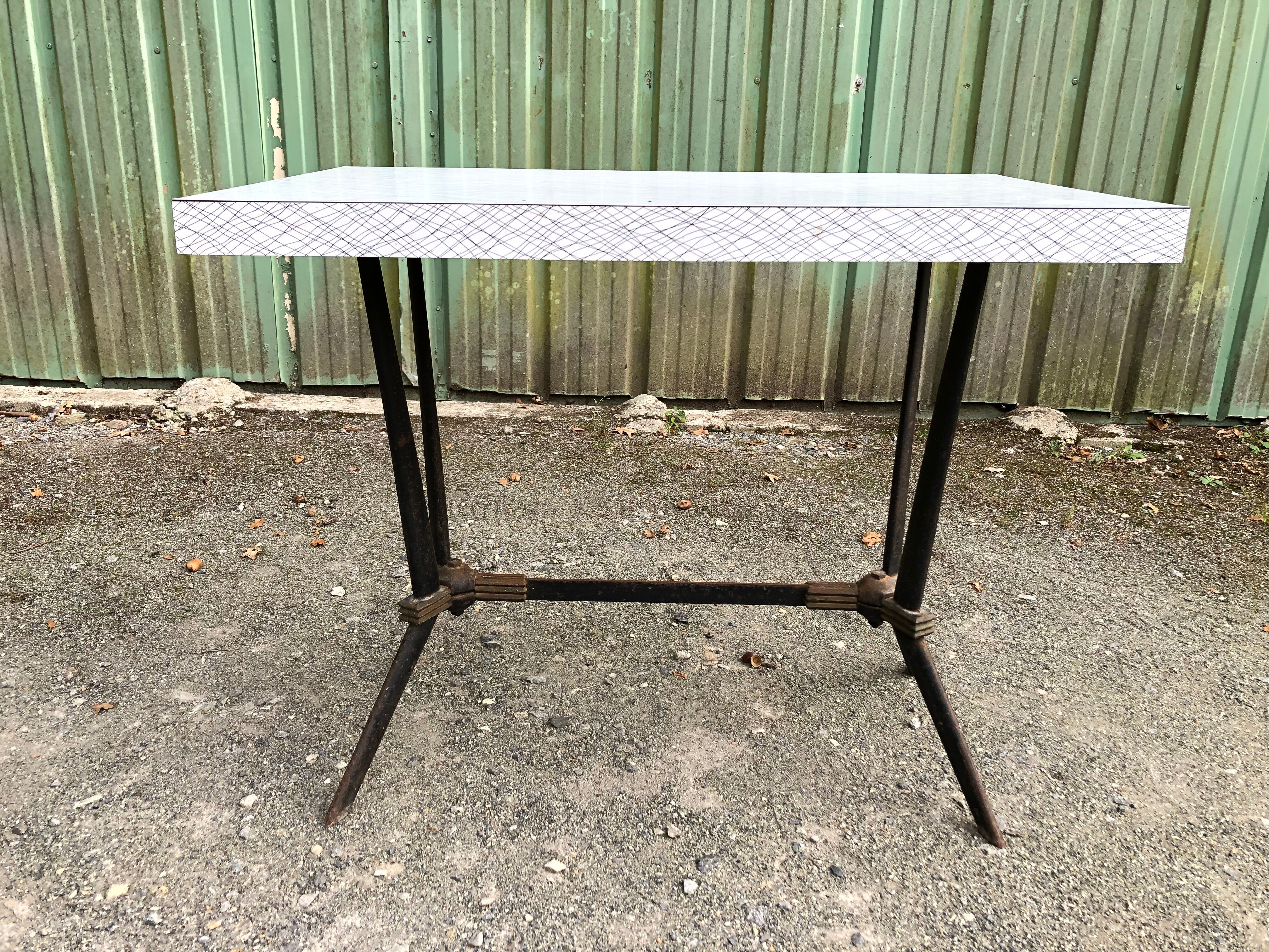 Vintage bistro table with an Art Deco style cast iron base and Formica top.