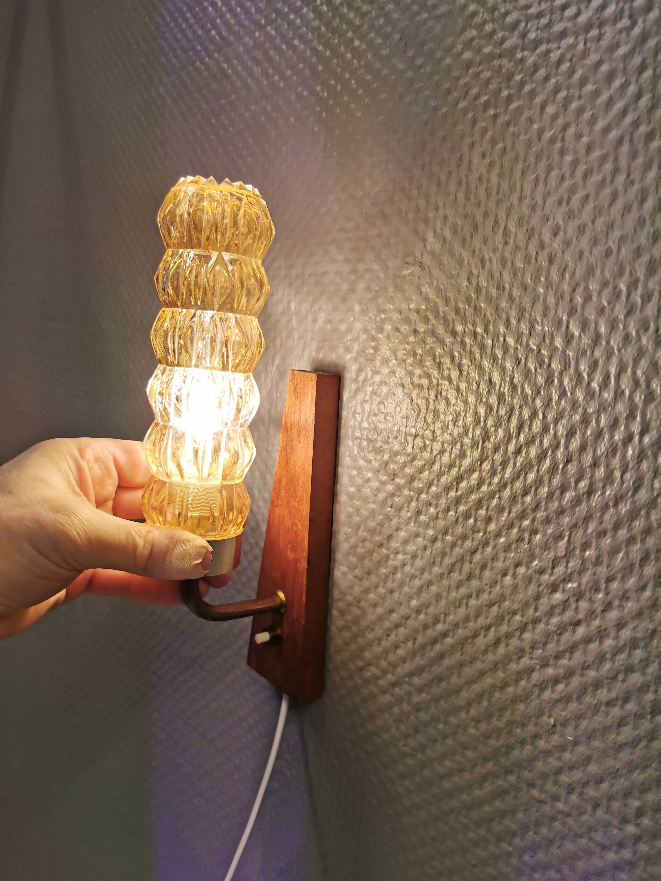 A set of Danish wall lights in champagne coloured glass with brass and teak.