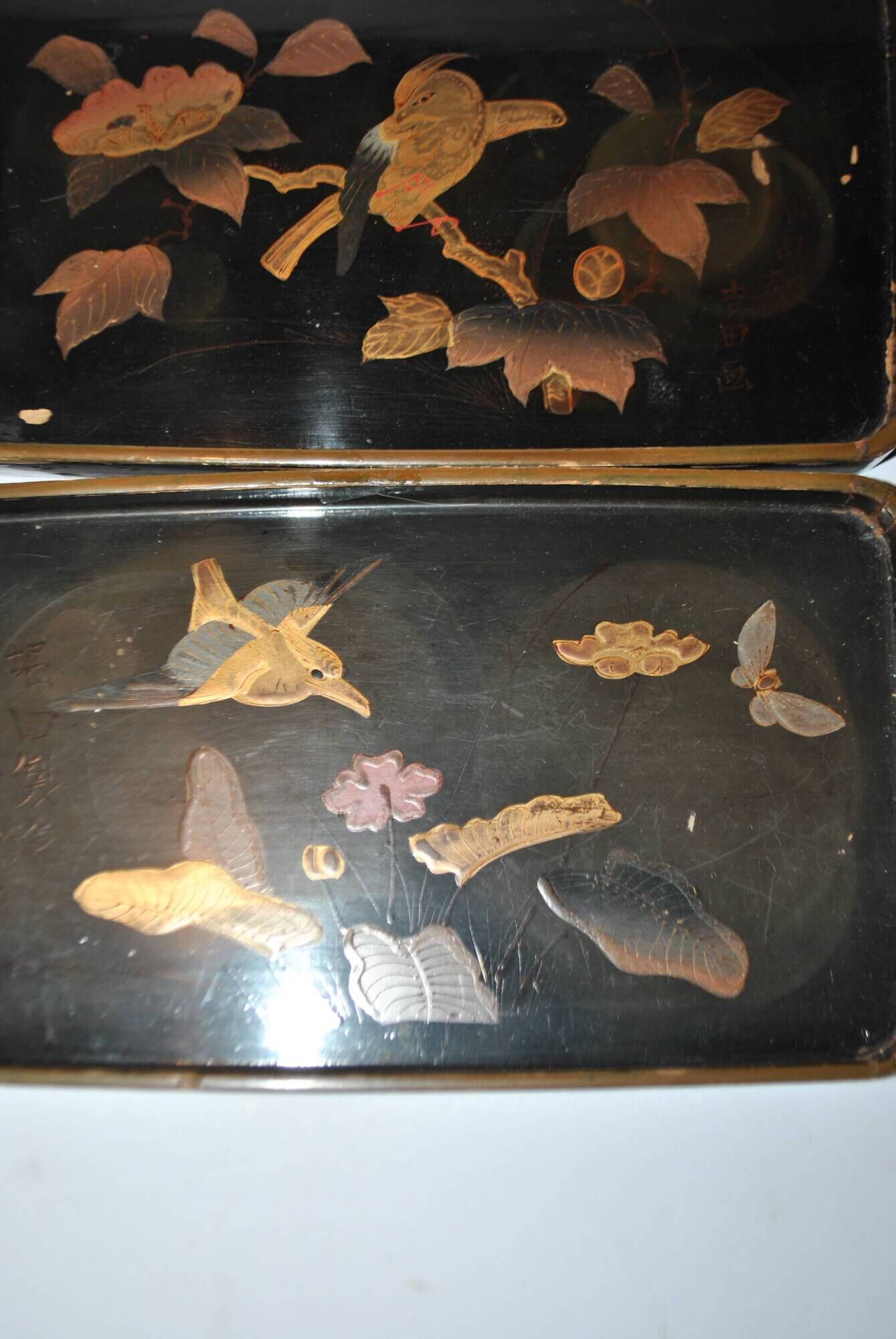 Set of two brown and black Chinese lacquer trays with bird decor