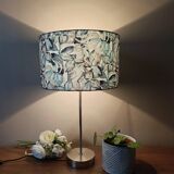 Table lamp with chrome stem, tropical plant shade.