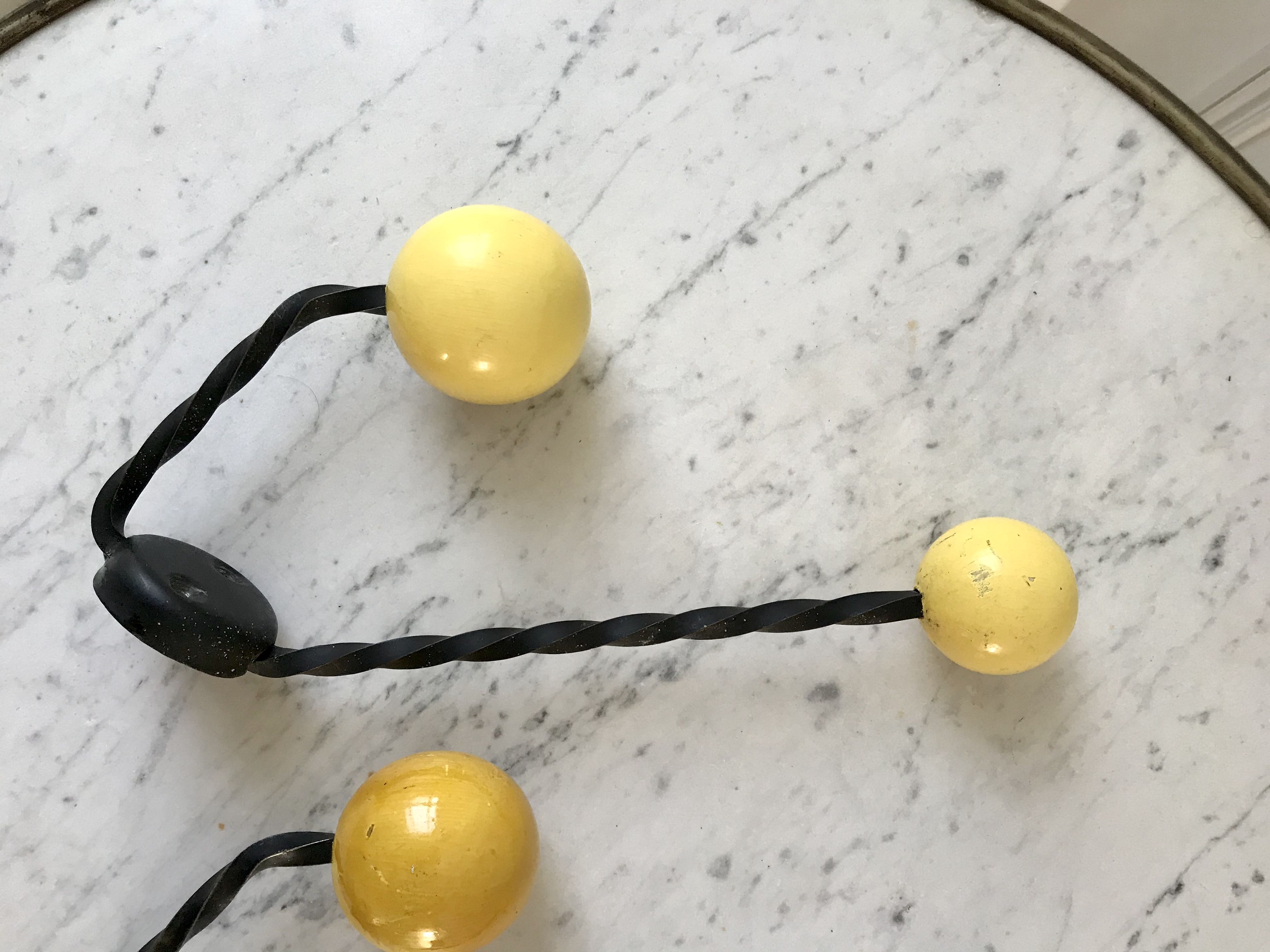 Duo of hooks balls in yellow wood and black iron 60s