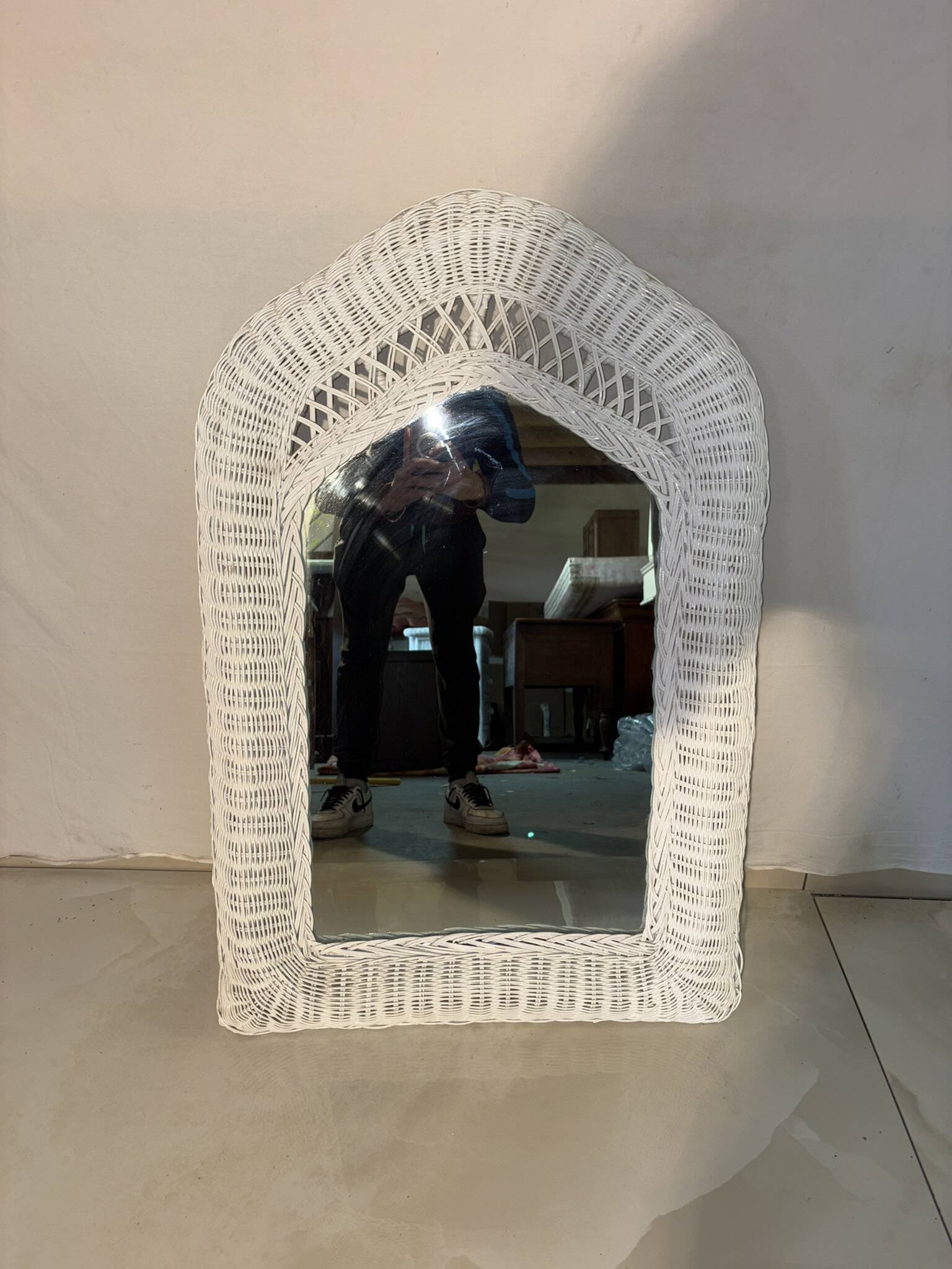 Vintage white rattan mirror with a gothic frame.