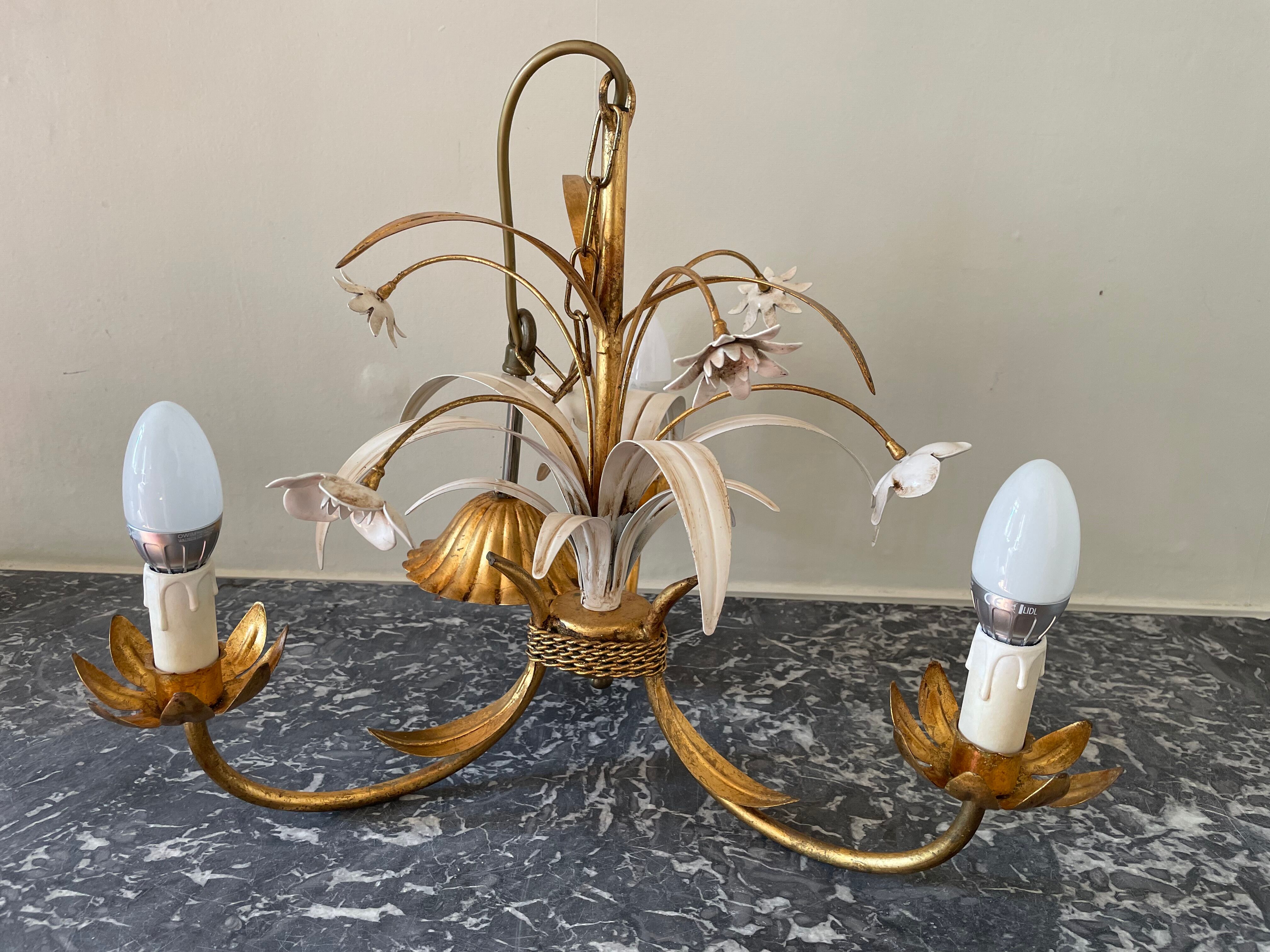 Golden metal chandelier decorated with flowers