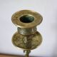 Brass candle holder with flowers and round shape.