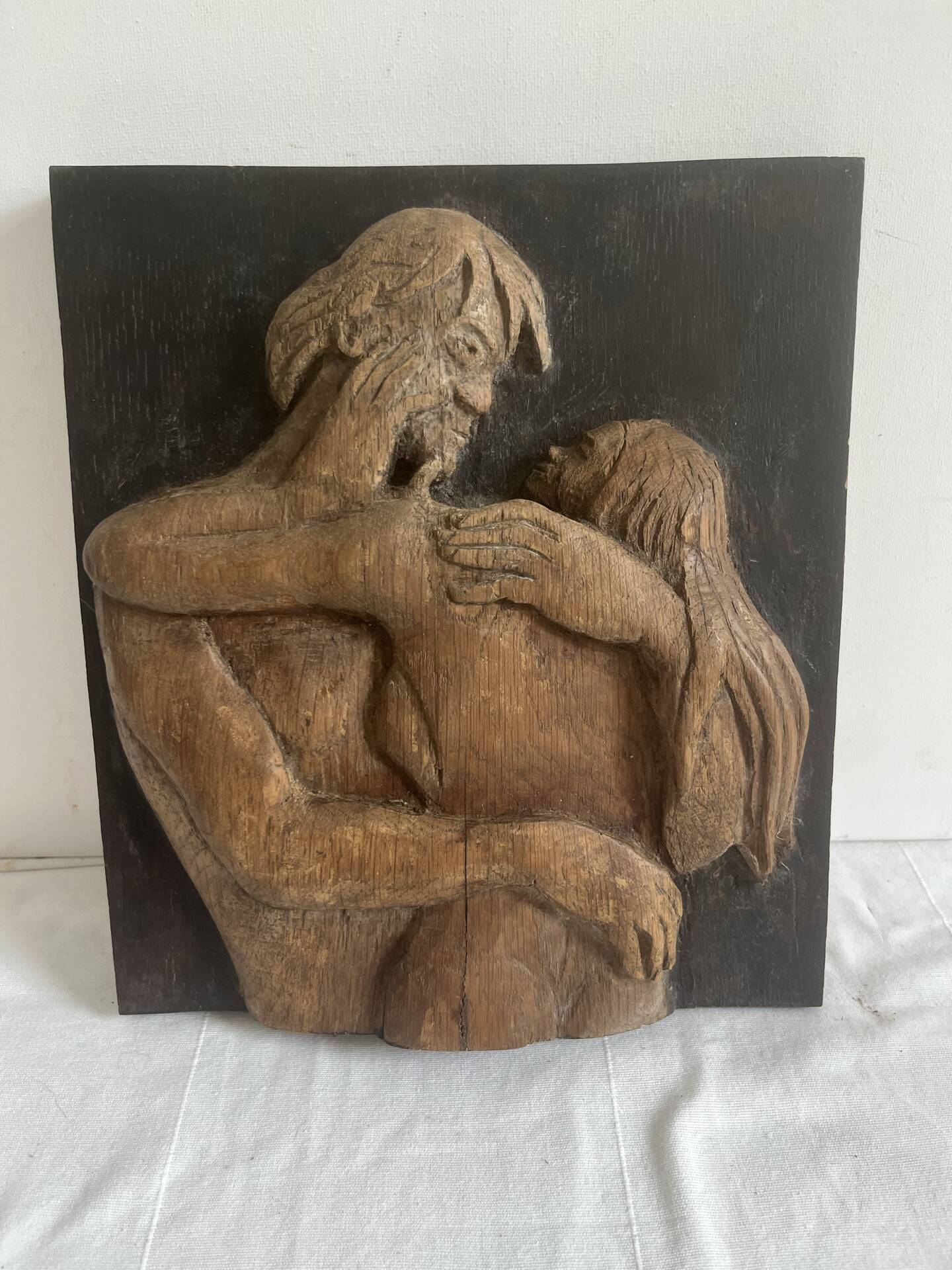Wood sculpture bas-relief of man, woman, and child, signed.