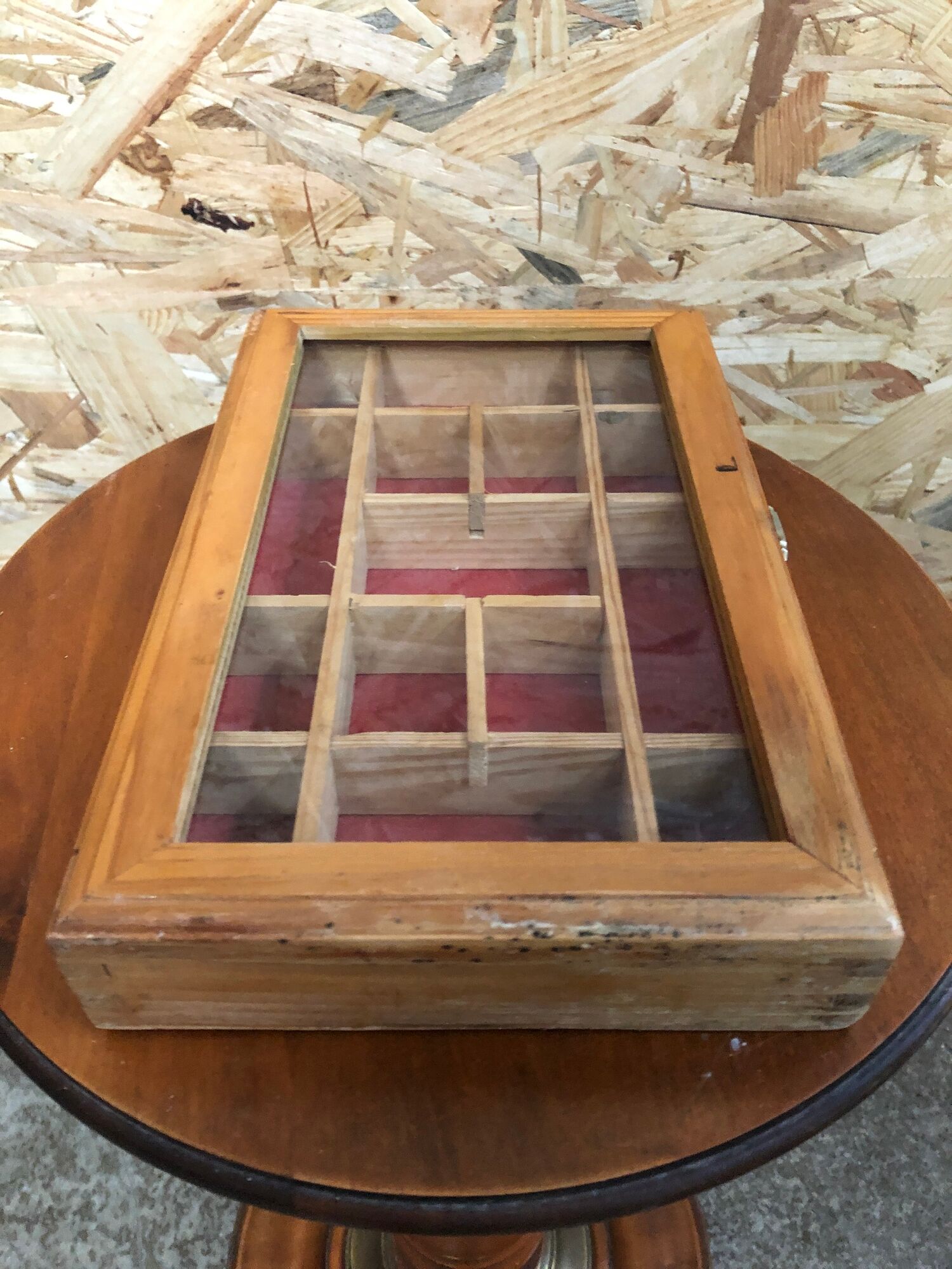 Old hanging display case with 15 wooden boxes, red background + vintage glass door