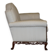 Three-seater canapé carved from solid walnut with claw feet.