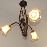 French Art Nouveau leaf detail iron three-light chandelier with amber glass shades.