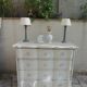 A beautifully crafted crossbow-shaped chest of drawers, finished in pearl grey with a whitewashed top.