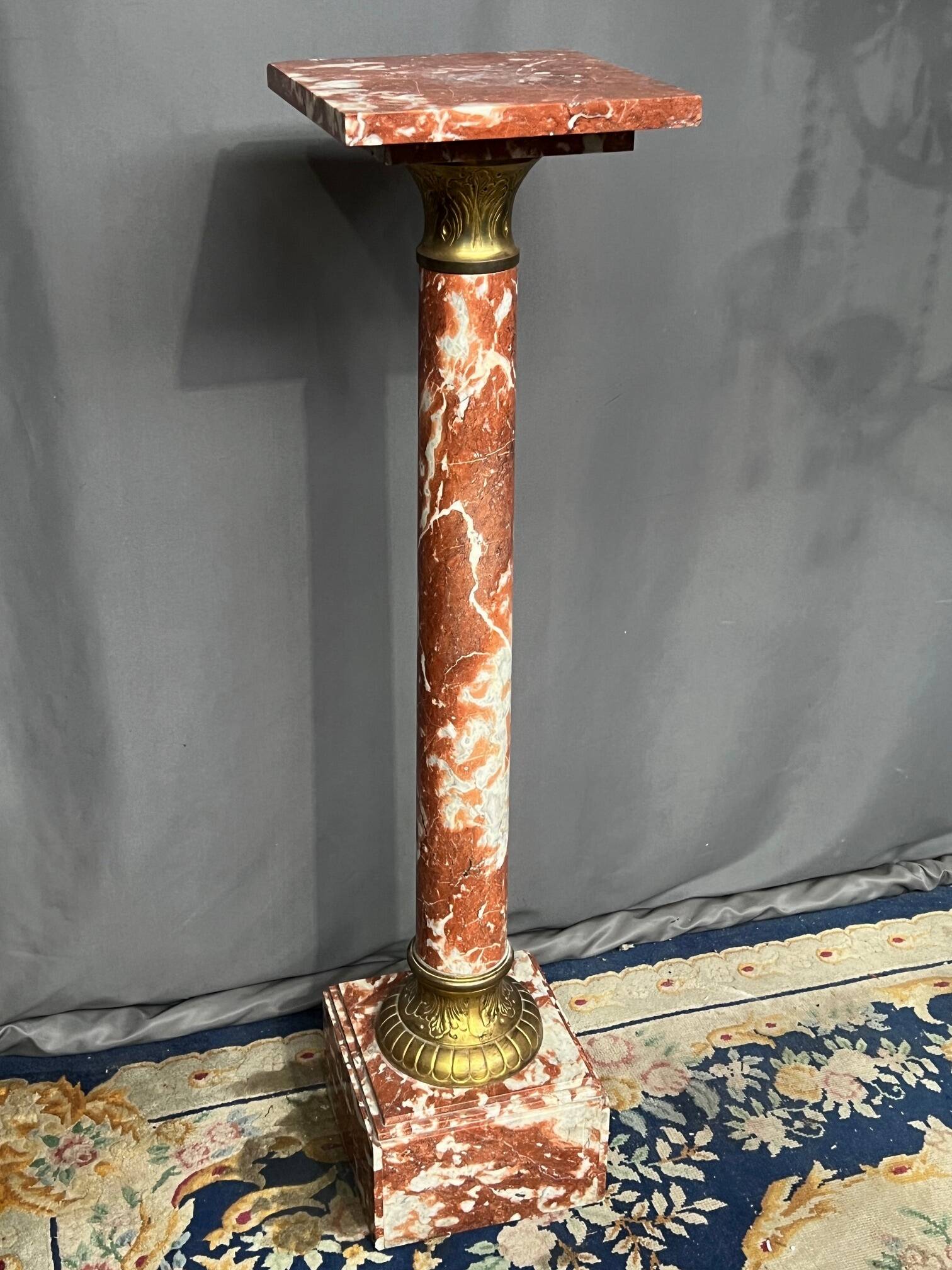 Marble pedestal decorated with gilded brass.