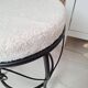 Black iron stool/pouf with its boucle fabric cushion.