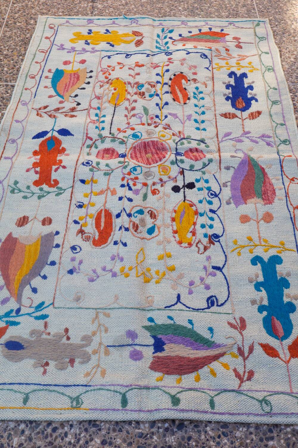 White suzani kilim rug with embroidered colorful patterns