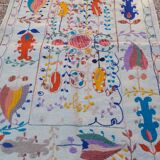 White suzani kilim rug with embroidered colorful patterns