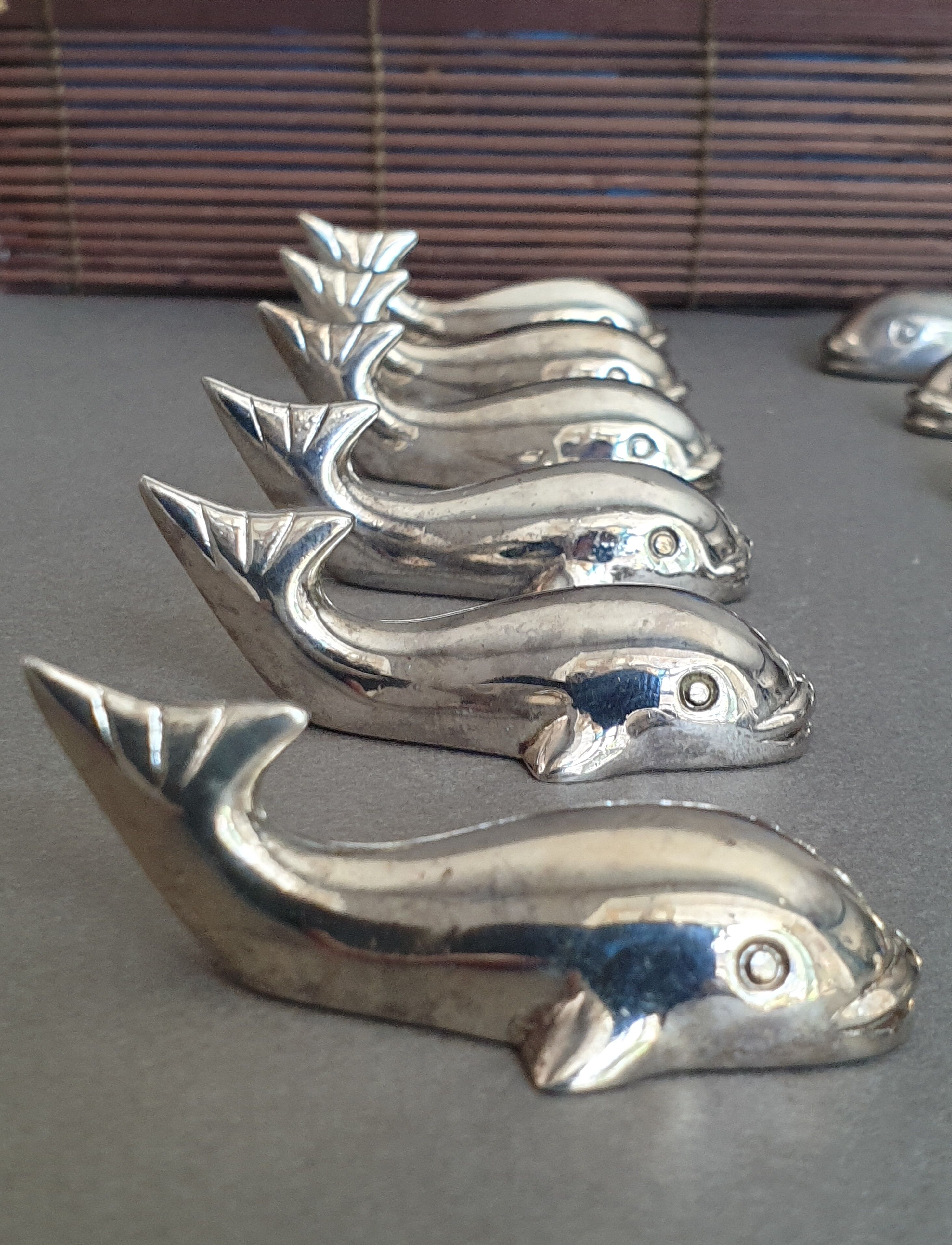 Lot 12 knife holders in the shape of a stylized whale or fish