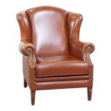 Correct, comfortable, luxurious English-style wingback armchair made of cognac-colored cow leather
