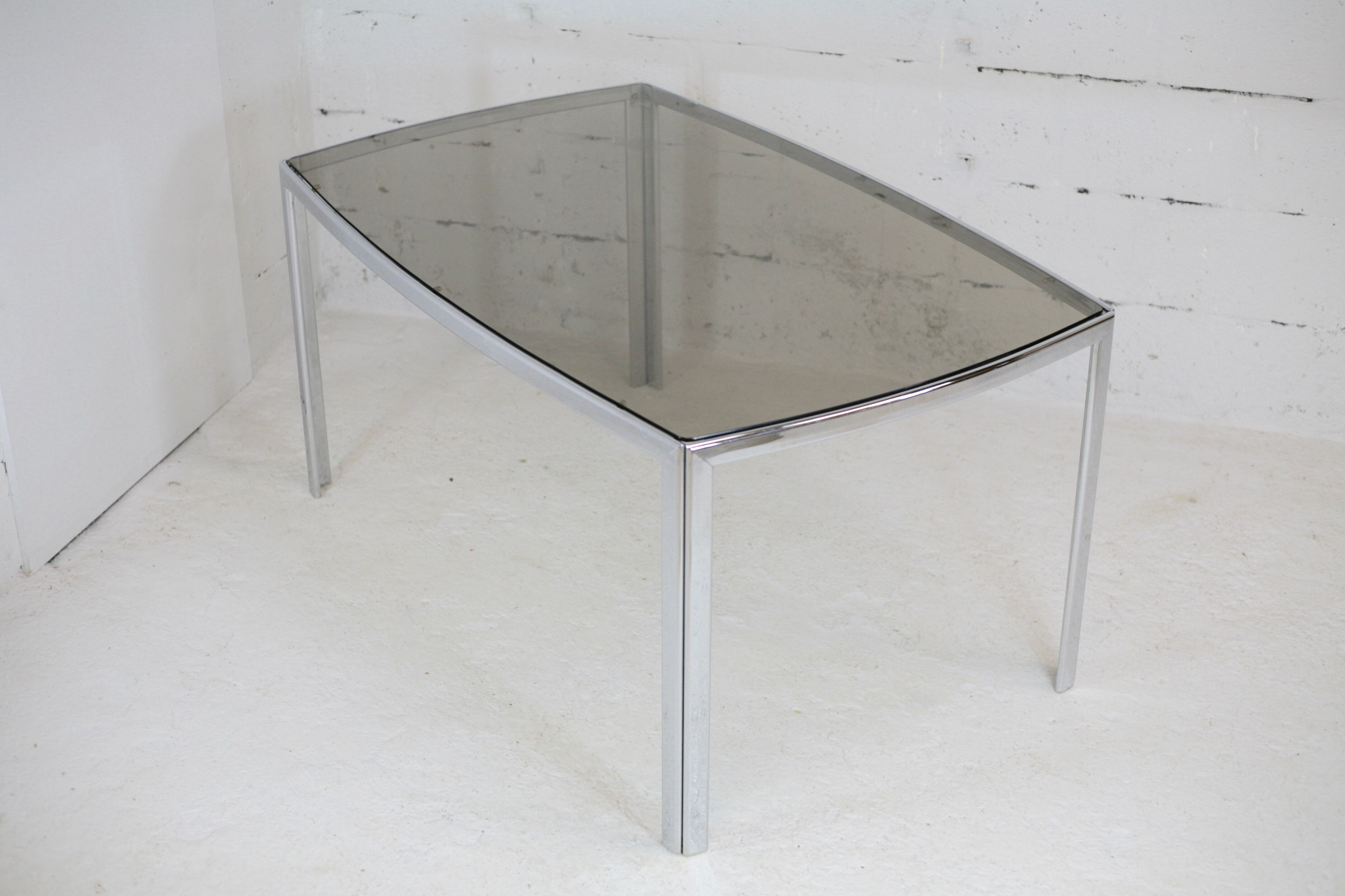 Living table. chrome metal, curved smoked glass slab, france, circa 1970.