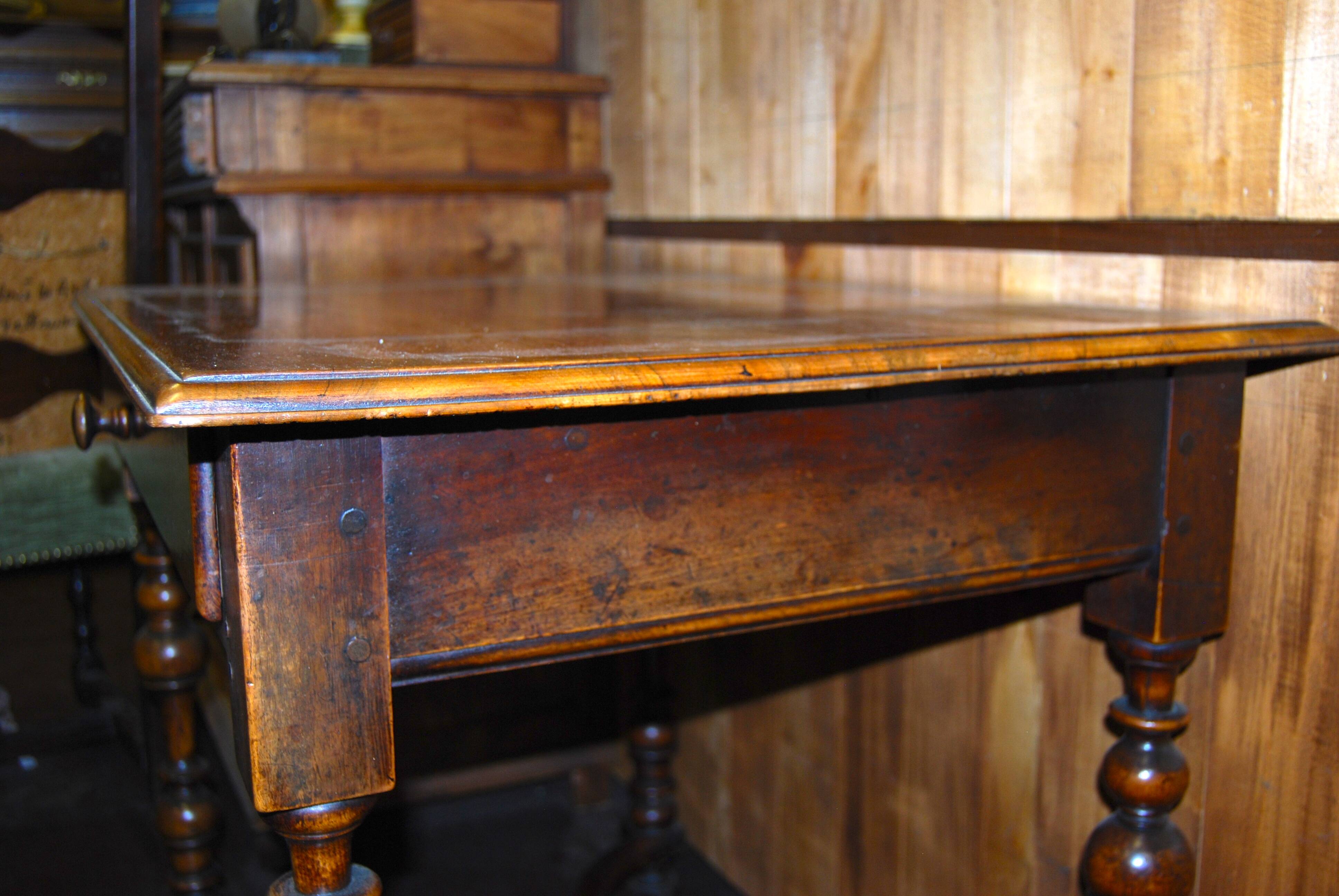 Table à écrire Louis XIII en noyer, pieds tournés en balustre entretoise en x.