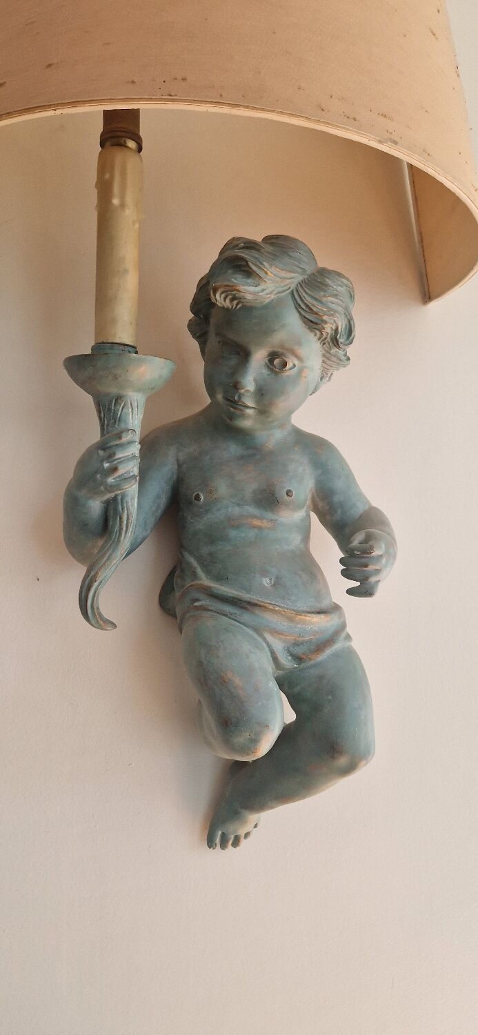 Pairs of wall lights, either two distinct cherubs.