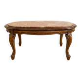 Oval coffee table in marble and carved wood in baroque style.