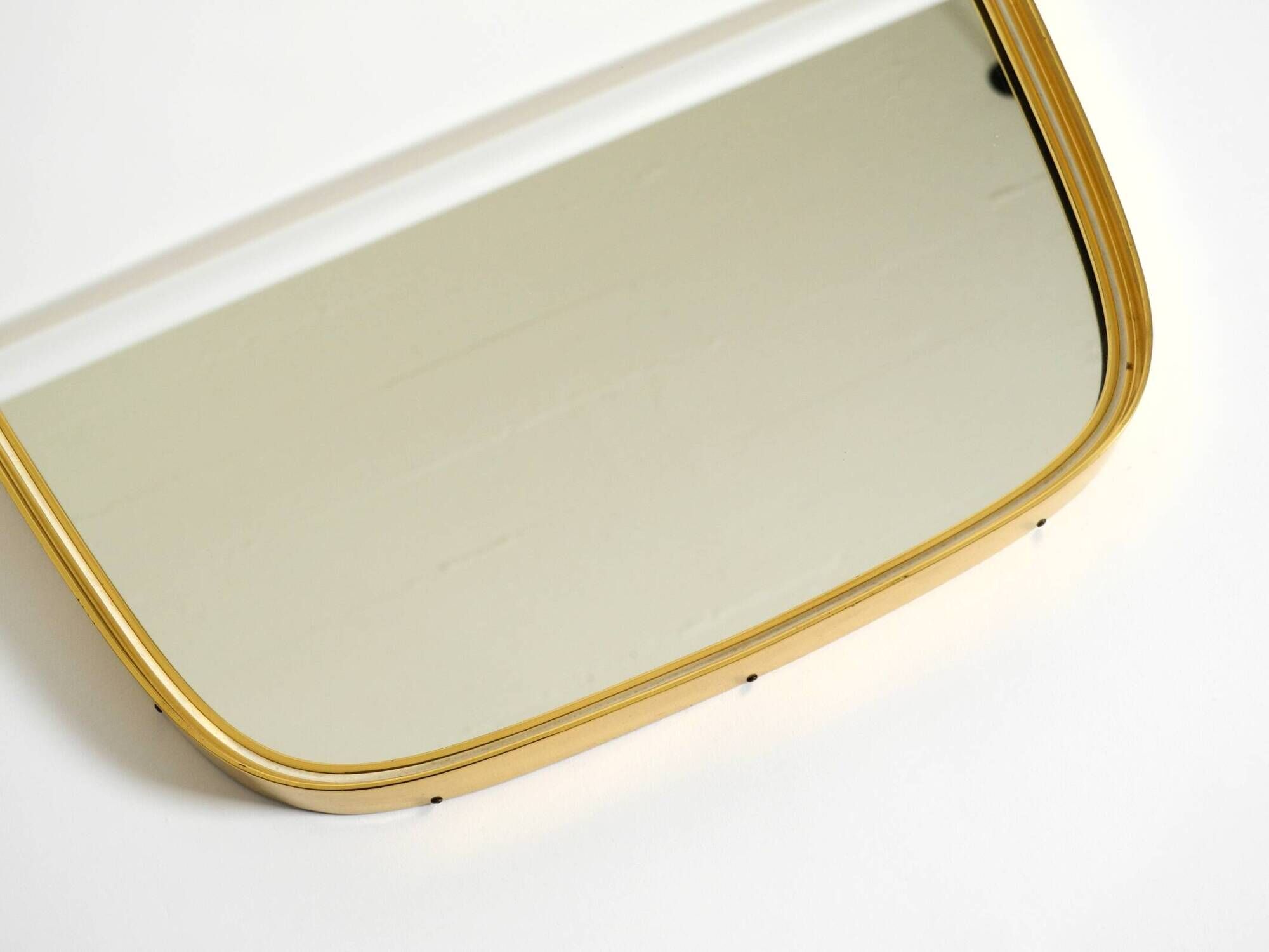 A pair of rare Mid Century "Münchener Zierspiegel" brass wall mirrors