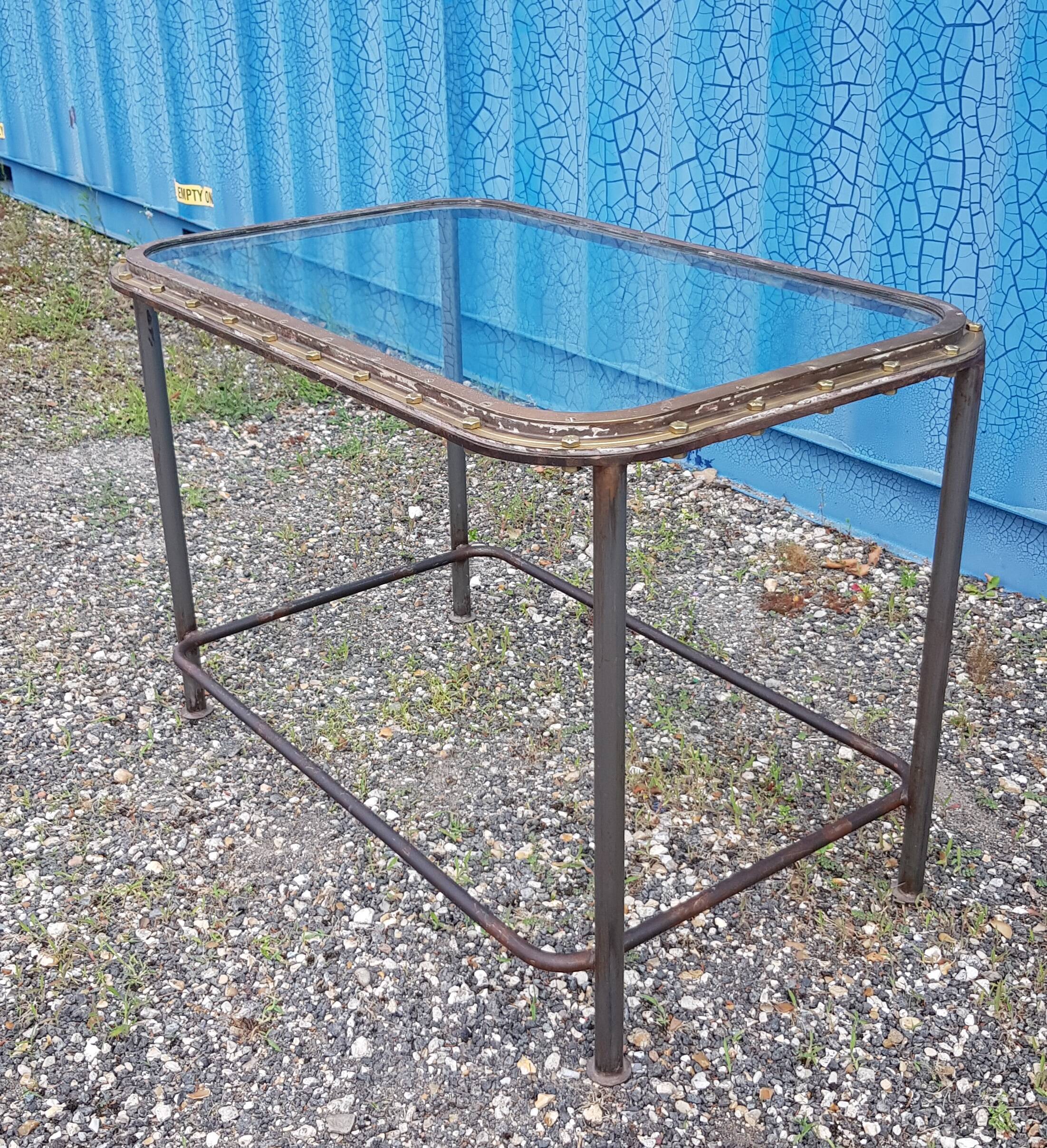 Table with an old ship porthole in brass and a metal base / 110 x 70 x 76 cm