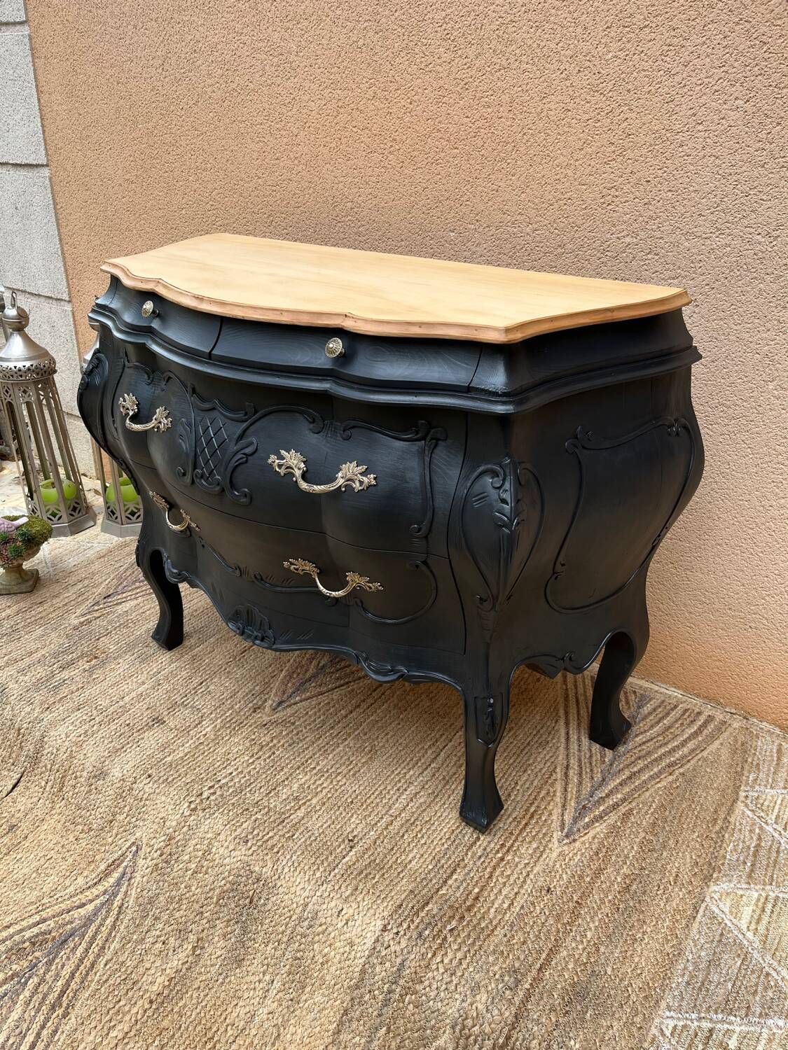 Curved commode painted in black and wood.