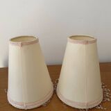 2 off-white fabric lampshades with pink and white tassels