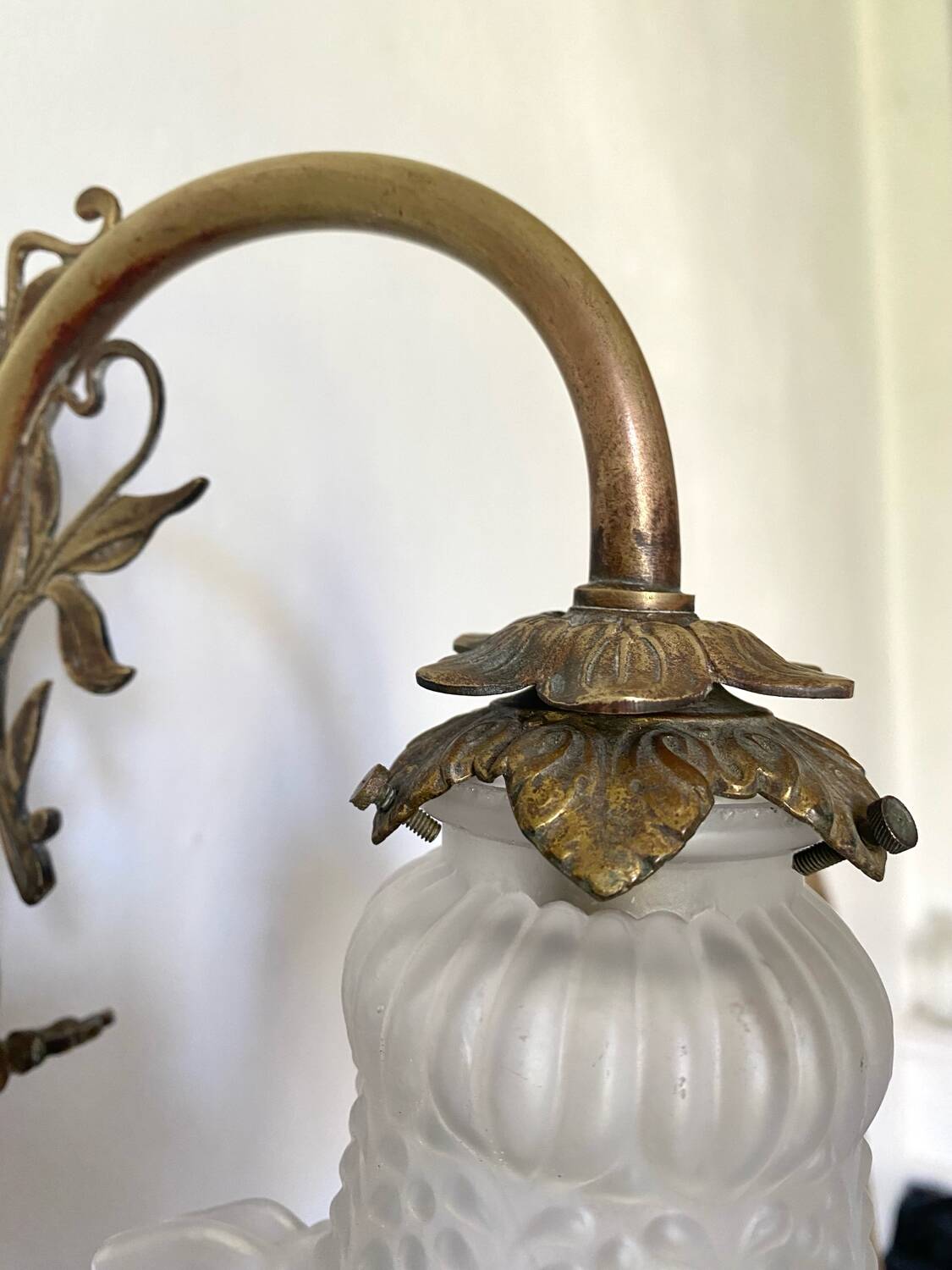 Antique brass wall light with glass shade.