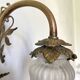 Antique brass wall light with glass shade.