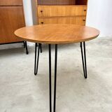 Round side table with black lacquered metal hairpin legs.