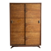 Vintage 1950s wardrobe with sliding wooden doors.