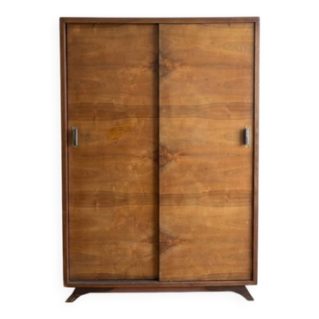 Vintage 1950s wardrobe with sliding wooden doors.