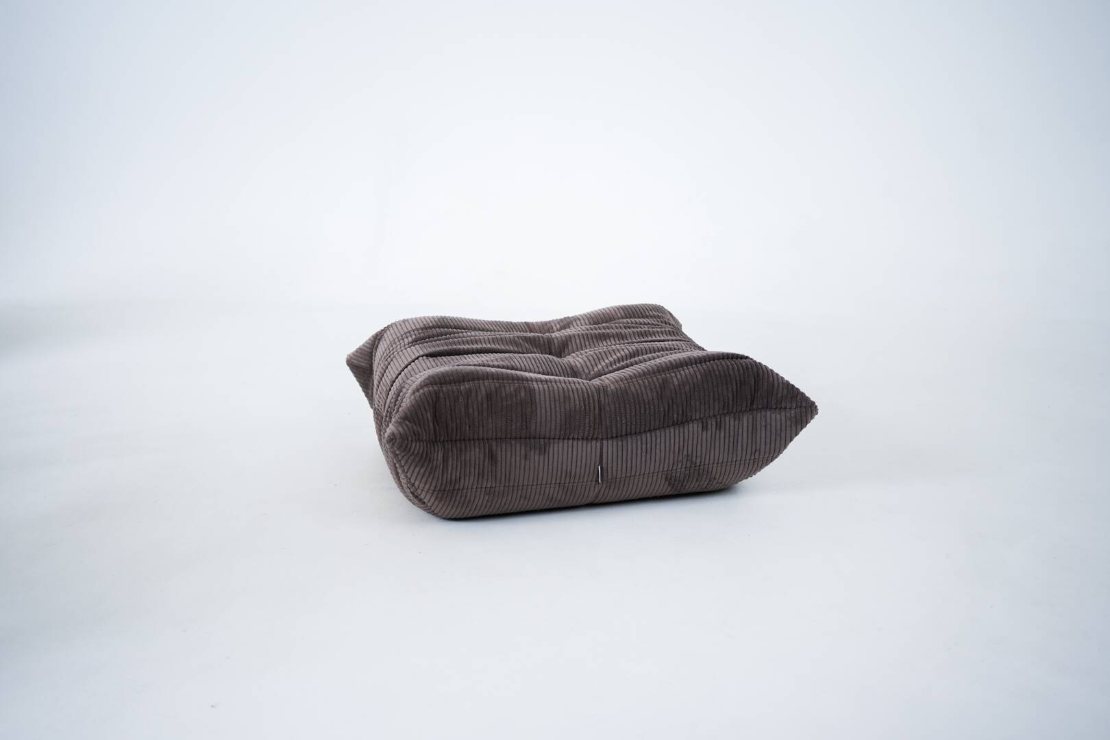 Ensemble de chaise et pouf Togo en velours côtelé marron.
