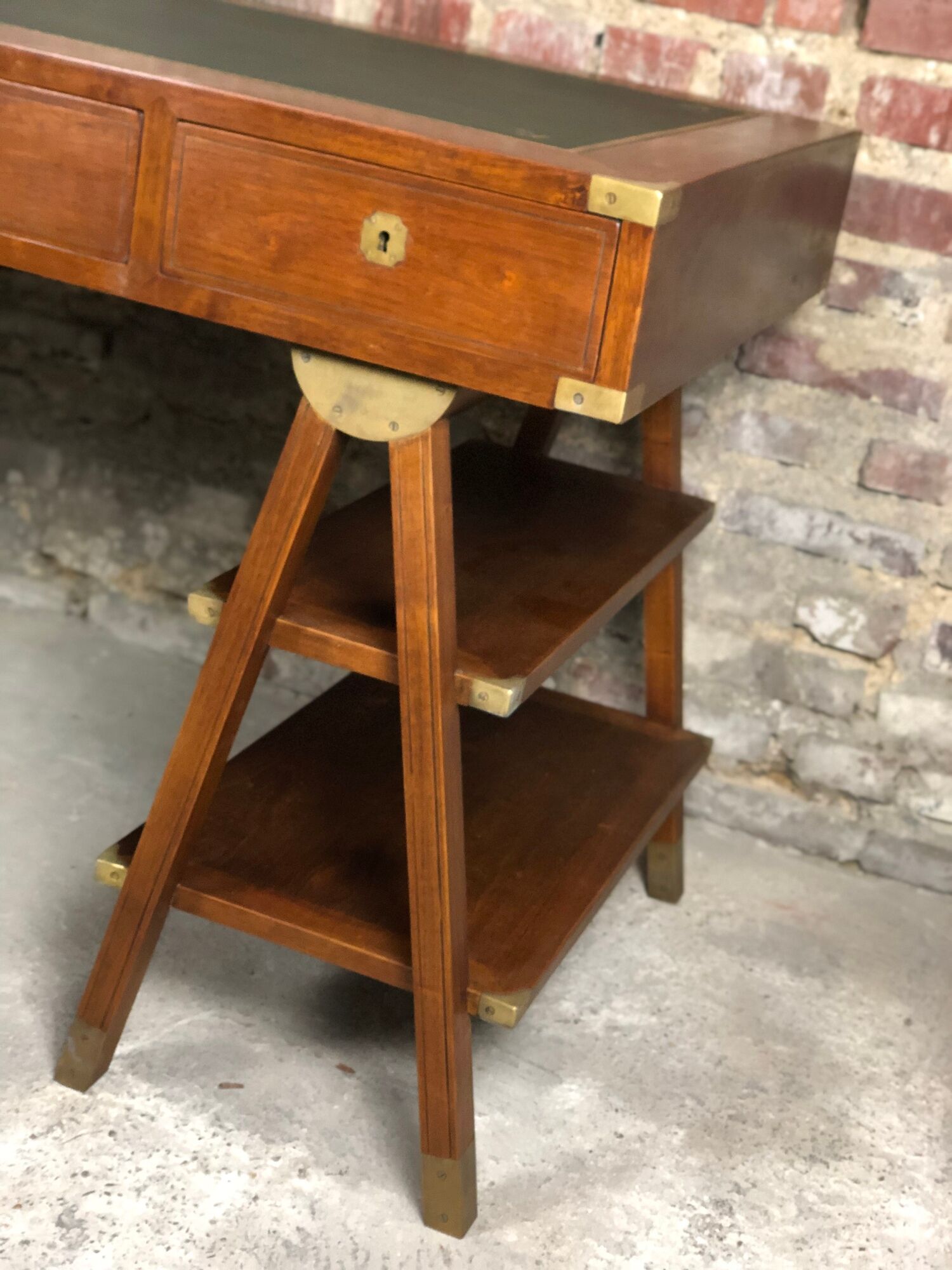 Walnut desk with green leather top resting on two trestles